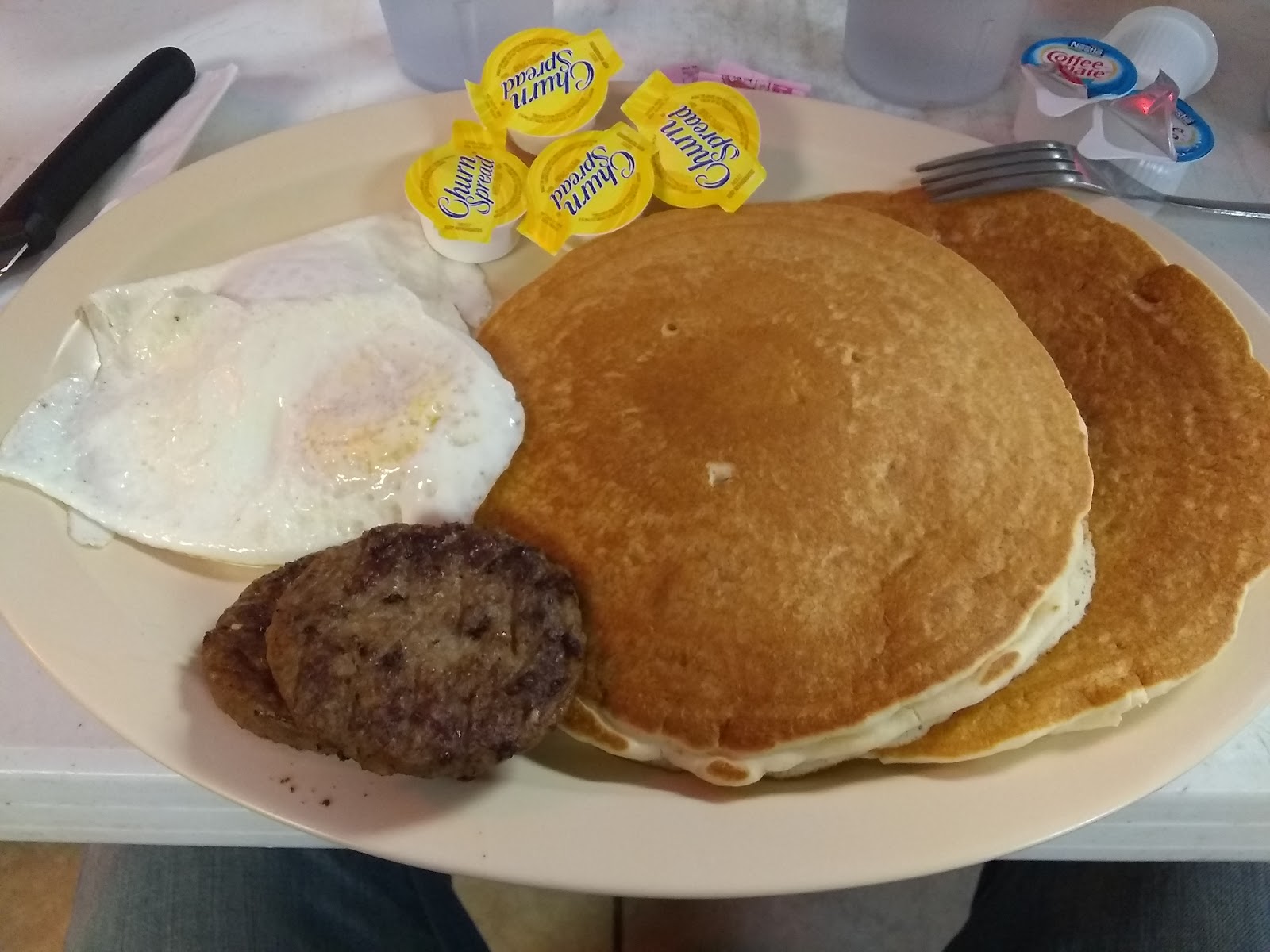 Pancake breakfast plate with eggs and sausage