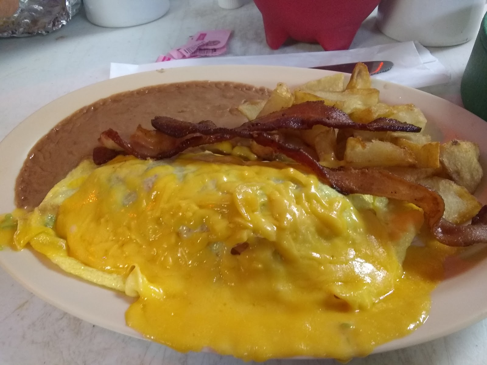 Breakfast plate with cheese eggs, bacon and fries
